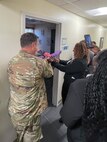 192nd Wing Commander and member of Kappa Epsilon Psi Military Sorority, Inc. cutting ribbon for doorway.