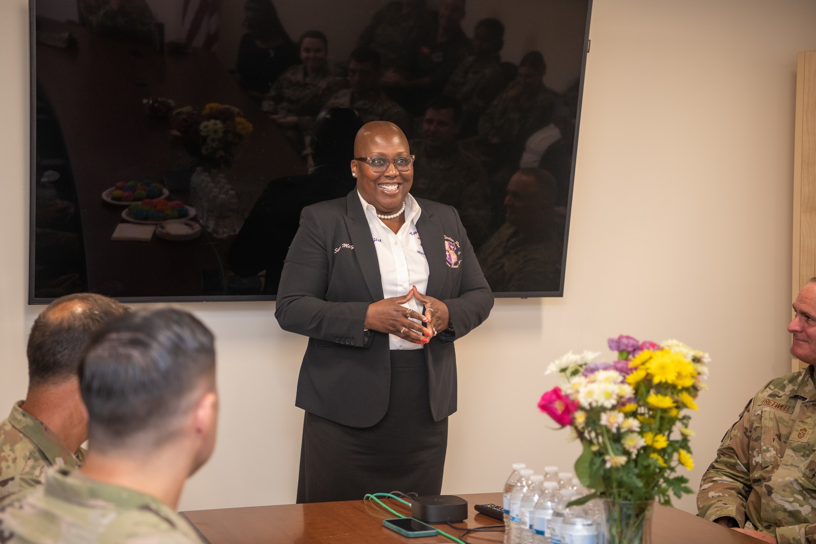 Member of Kappa Epsilon Psi Military Sorority, Inc. speaking in conference room.