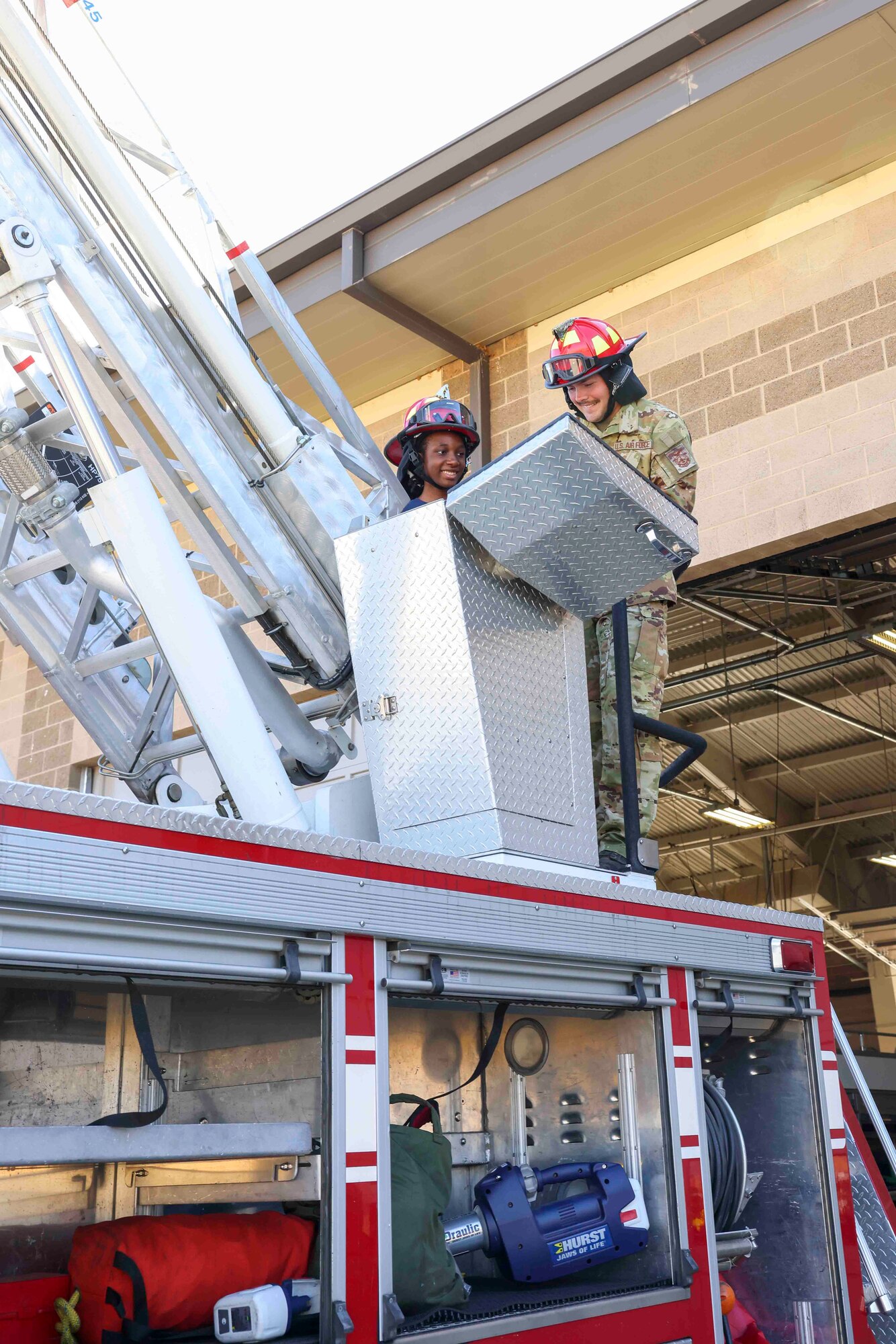 U.S. Air Force Senior Airman Shawn-Anthony Wade, a 9th Civil Engineer Squadron firefighter, shows Azalia Mutebi, a student with For Inspiration and Recognition of Science and Technology (FIRST) the operational features of the firetruck during a base tour Aug. 3, 2023, at Beale Air Force Base, California.