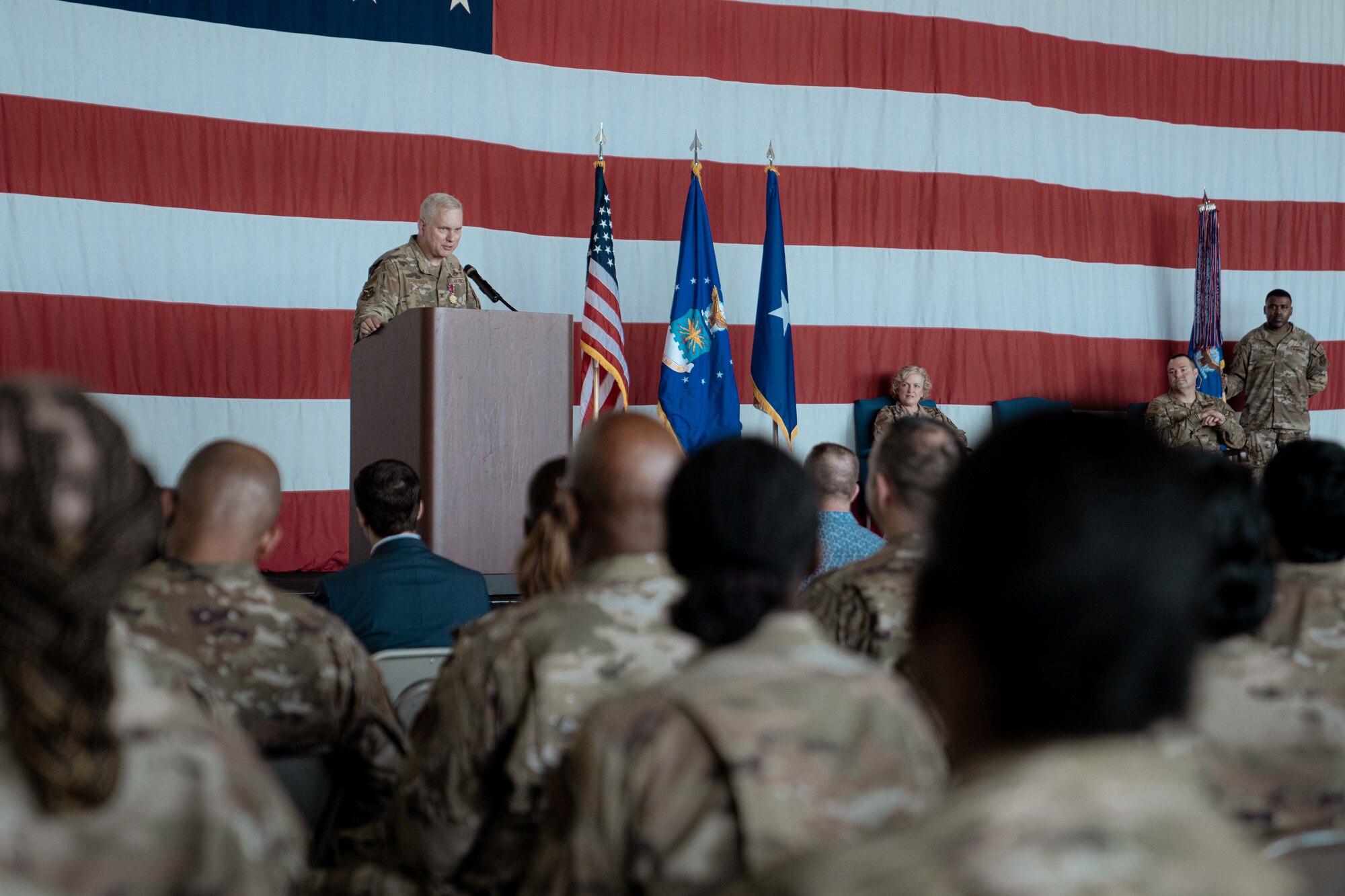 Col. Carl Magnusson, 94th Airlift Wing outgoing commander, speaks on-stage to the Airmen of the 94th during his change of command ceremony.