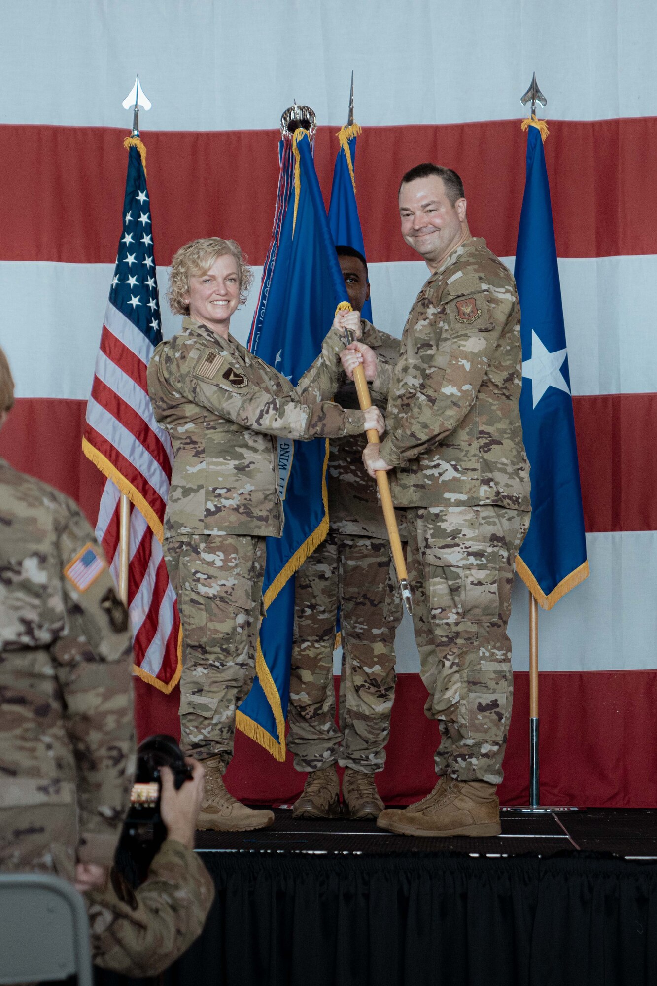 Brig. Gen. Melissa A. Coburn, 22nd Air Force commander, passes the guidon flag of the 94th Airlift Wing to Col. Michael Parks.
