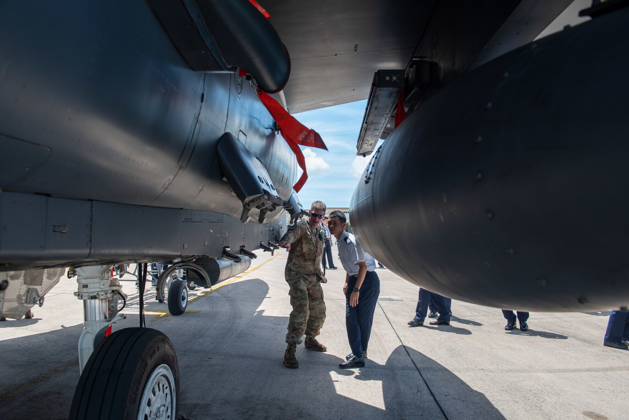 Airman speaks to a JASDF cadet by an F-15E Strike Eagle