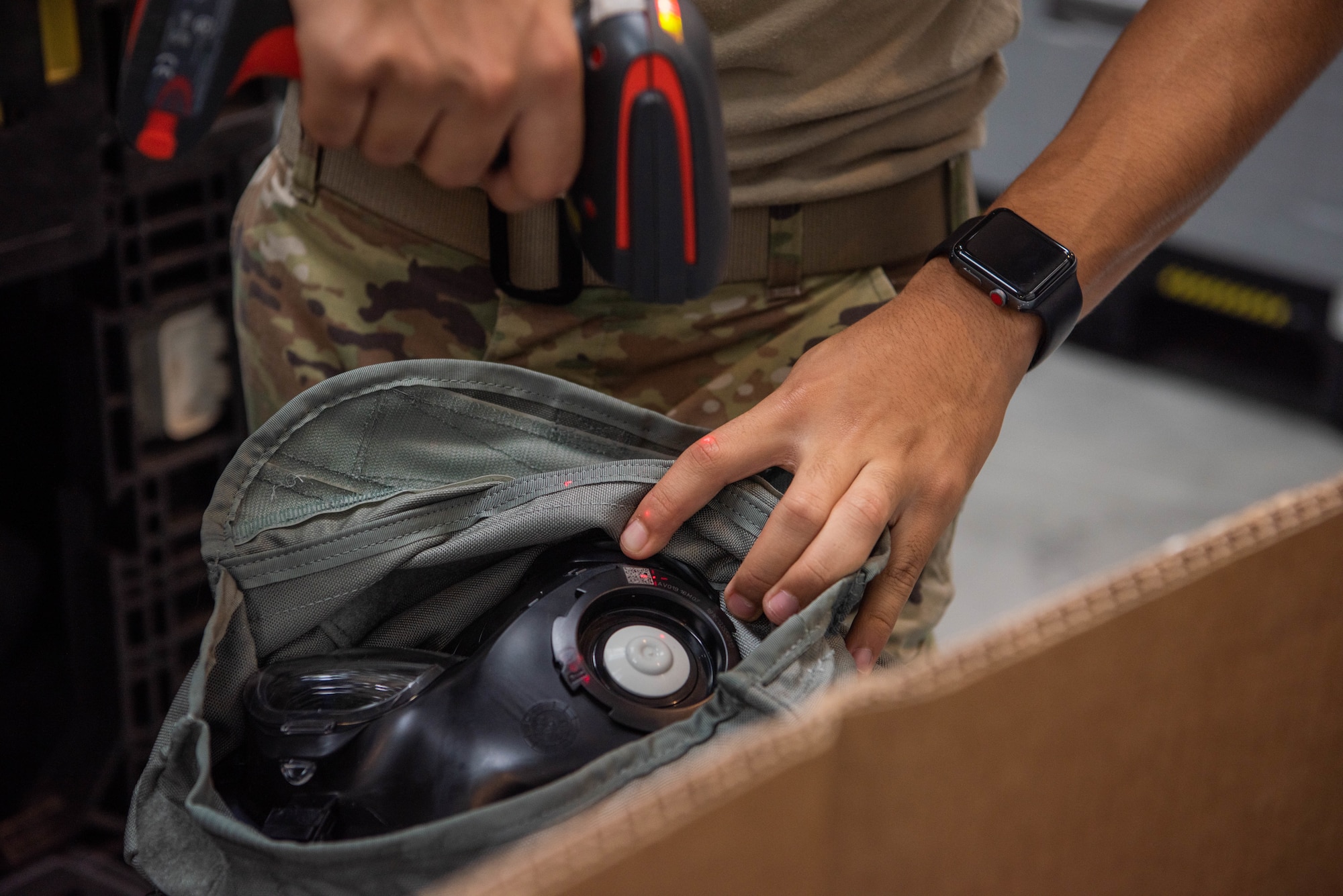 Airman scans gas mask for inventory.