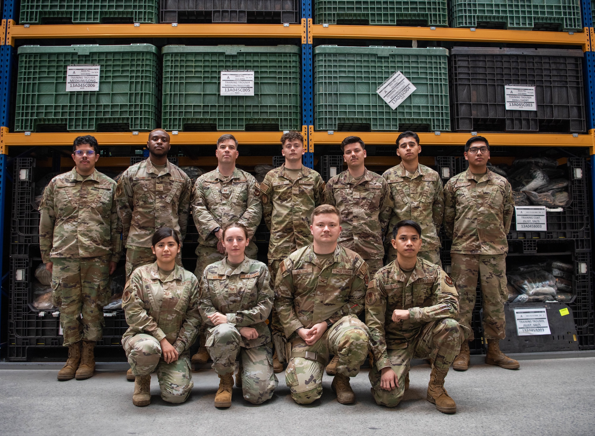Airman stand for group photo in warehouse.