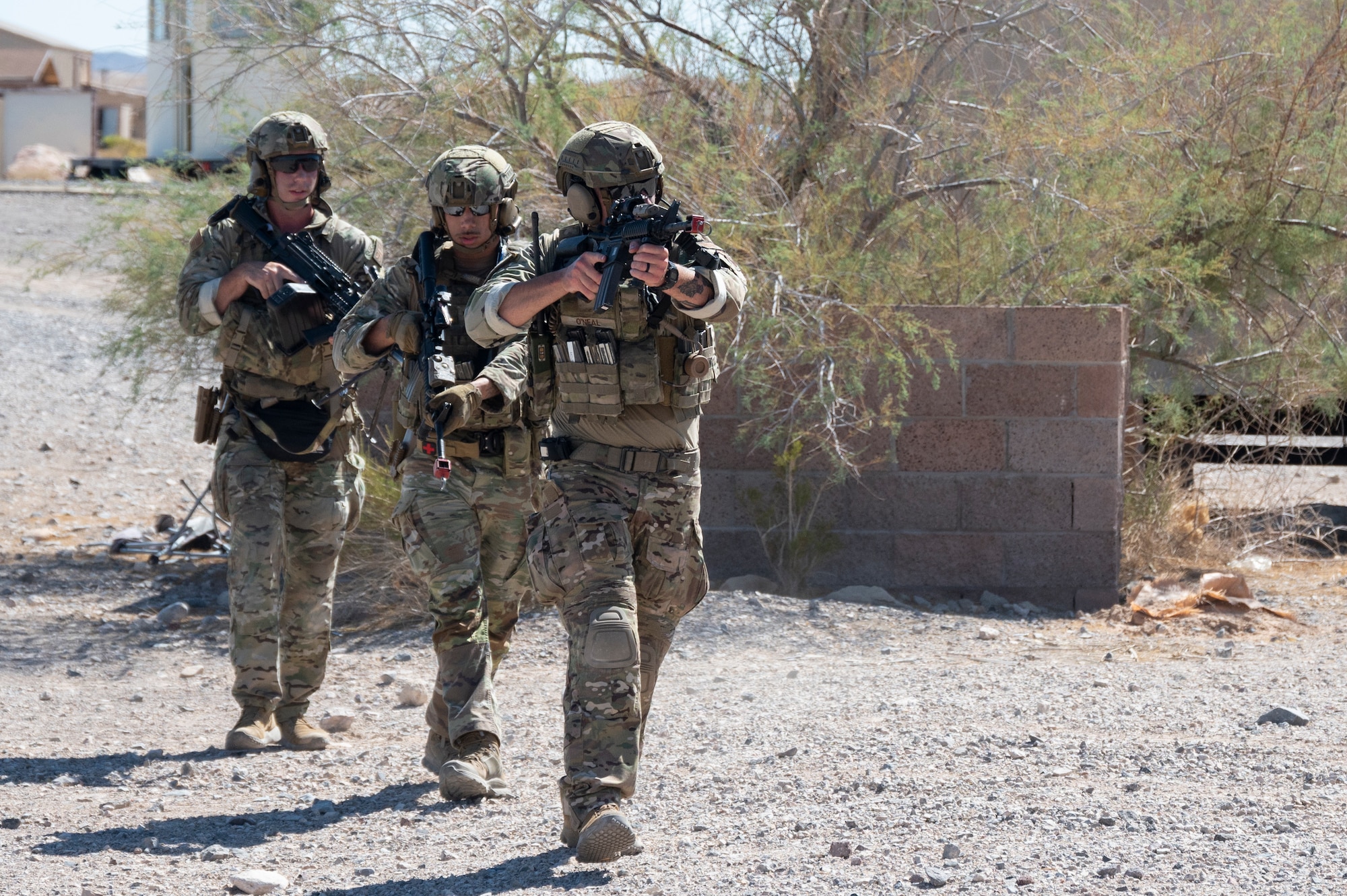 Three U.S. Airmen move tactically during an air base defense rehearsal during exercise Red Flag 23-3 at Nellis AFB, Nevada, July 20, 2023. These defenders were establishing security for the forward operating site and contingency locations necessary to perform Agile Combat Employment. (U.S. Air Force photo by Master Sgt. Niles Bartram)