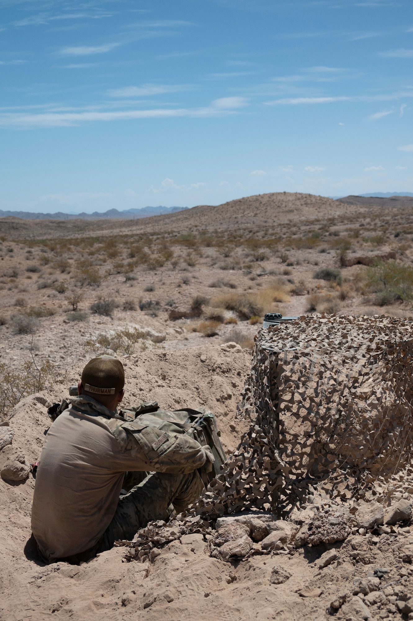 A U.S. Base Defense Squadron Airman digs during an air base defense rehearsal during exercise Red Flag 23-3 at Nellis AFB, Nevada, July 25, 2023. These defenders were establishing security for the forward operating site and contingency locations necessary to perform Agile Combat Employment. (U.S. Air Force photo by Master Sgt. Niles Bartram)
