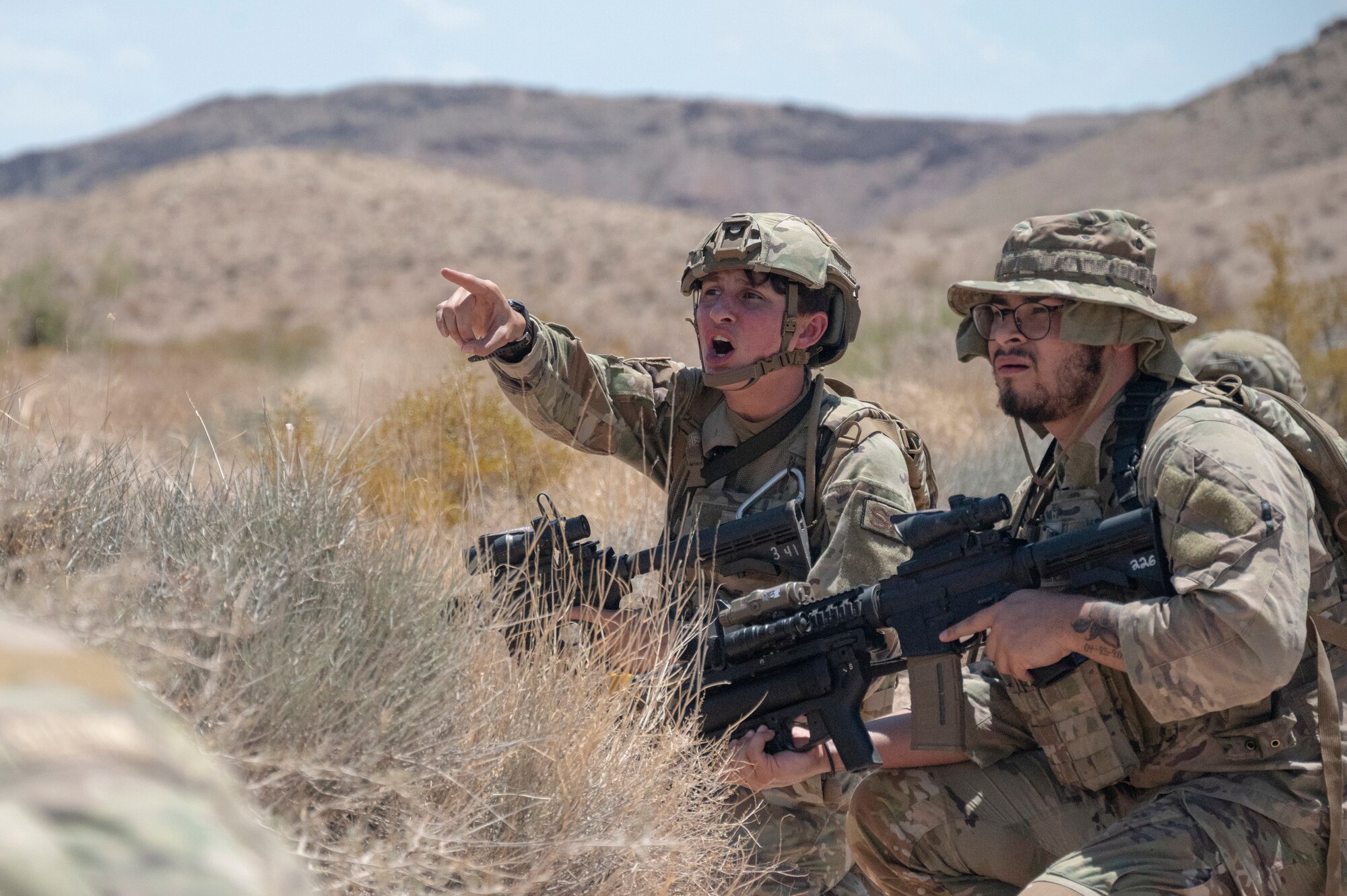 A U.S. Airman yells during an air base defense rehearsal during exercise Red Flag 23-3 at Nellis AFB, Nevada, July 25, 2023. These defenders were establishing security for the forward operating site and contingency locations necessary to perform Agile Combat Employment. (U.S. Air Force photo by Master Sgt. Niles Bartram)