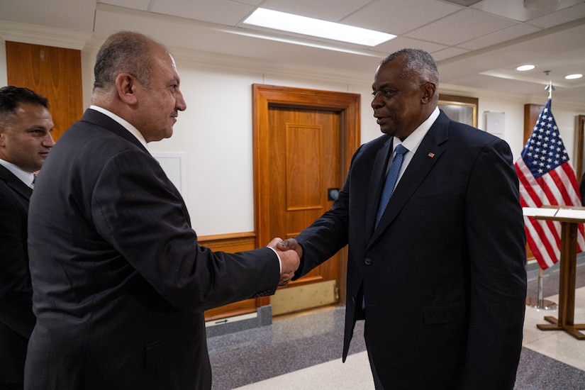 Two men shake hands.