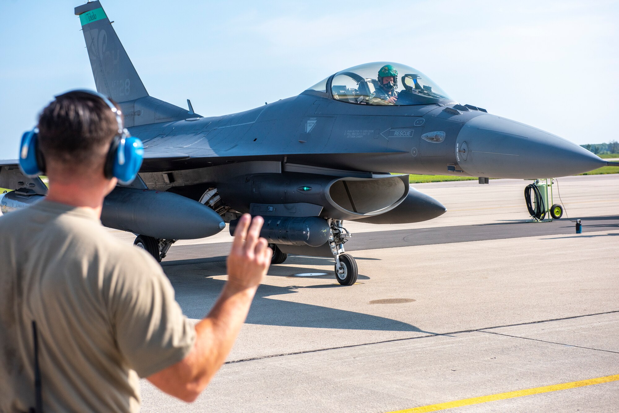 U.S. Air Force Master Sgt. Stephen Boehme, assigned to the Ohio Air National Guard 180th Fighter Wing, directs an F-16 Fighting Falcon to Volk Field on Camp Douglas, Wis., during Exercise Northern Lightning, Aug. 7, 2023.