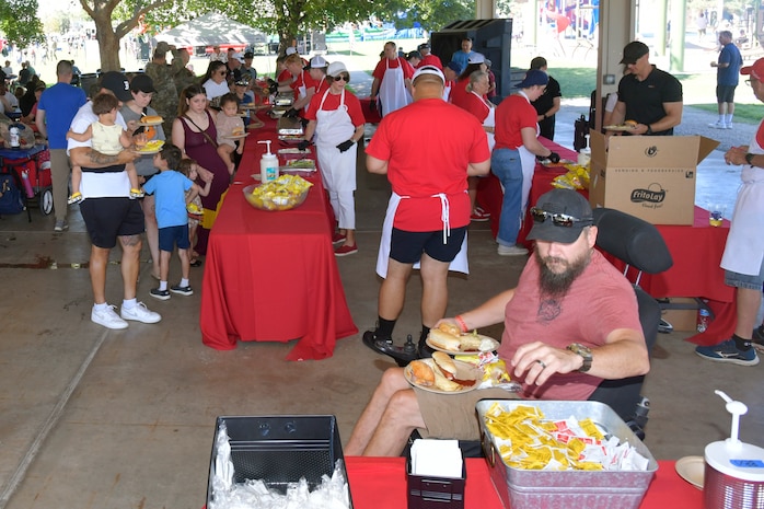 Military families enjoy picnic food.
