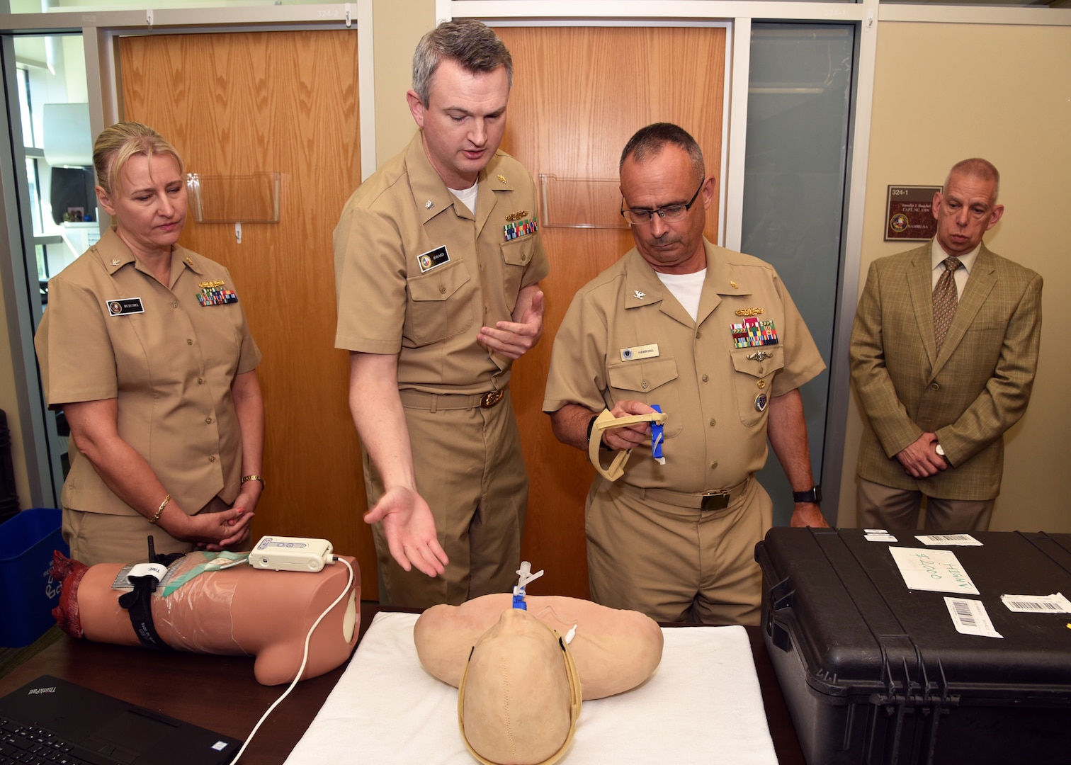 JOINT BASE SAN ANTONIO-FORT SAM HOUSTON – (Aug. 3, 2023) – Cmdr. Drew Havard, deputy director, Craniofacial Health and Restorative Medicine (CHRM), Naval Medical Research Unit (NAMRU) San Antonio, joined by Capt. Jennifer Buechel, incoming commanding officer, and Chief Science Director Dr. Sylvain Cardin, briefs Capt. Robert Hawkins, director, J3/5/7, Defense Health Agency (DHA) and director, U.S. Navy Nurse Corps, on a NAMRU San Antonio-invented trachea device during a tour of NAMRU San Antonio facilities at the Battlefield Health and Trauma Research Institute. NAMRU San Antonio’s mission is to conduct gap driven combat casualty care, craniofacial, and directed energy research to improve survival, operational readiness, and safety of Department of Defense (DoD) personnel engaged in routine and expeditionary operations. It is one of the leading research and development laboratories for the U.S. Navy under the DoD and is one of eight subordinate research commands in the global network of laboratories operating under Naval Medical Research Command in Silver Spring, Md. (U.S. Navy photo by Burrell Parmer, NAMRU San Antonio Public Affairs/Released)