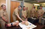 JOINT BASE SAN ANTONIO-FORT SAM HOUSTON – (Aug. 3, 2023) – Cmdr. Drew Havard, deputy director, Craniofacial Health and Restorative Medicine (CHRM), Naval Medical Research Unit (NAMRU) San Antonio, joined by NAMRU San Antonio leaders, and Capt. William Deniston, commander, Naval Medical Research Command (NMRC), briefs Capt. Robert Hawkins, director, J3/5/7, Defense Health Agency (DHA) and director, U.S. Navy Nurse Corps, on a NAMRU San Antono-invented trachea device during a tour of NAMRU San Antonio facilities at the Battlefield Health and Trauma Research Institute. NAMRU San Antonio’s mission is to conduct gap driven combat casualty care, craniofacial, and directed energy research to improve survival, operational readiness, and safety of Department of Defense (DoD) personnel engaged in routine and expeditionary operations. It is one of the leading research and development laboratories for the U.S. Navy under the DoD and is one of eight subordinate research commands in the global network of laboratories operating under NMRC in Silver Spring, Md. (U.S. Navy photo by Burrell Parmer, NAMRU San Antonio Public Affairs/Released)