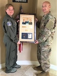 Illinois Air National Guard Senior Master Sgt. David Schreffler (right) receives a plaque from his sister, Col. LaDonna Schreffler, after he reached 30 years of Air Force service.