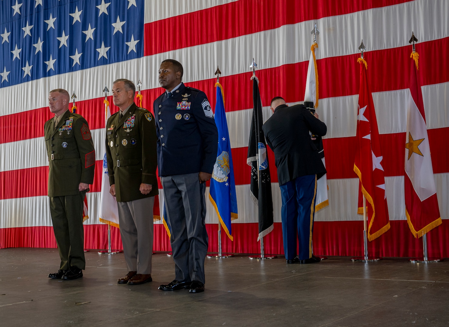 U.S. Army Gen. James Dickinson, U.S. Space Command commander; U.S. Marine Corps Master Gunnery Sgt. Scott Stalker; and U.S. Space Force Chief Master Sgt. Jacob Simmons stand at attention during USSPACECOM's second-ever change of responsibility ceremony Aug. 7, 2023, at Peterson Space Force Base, Colo.