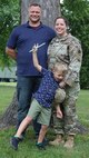 Five-year-old George Steven poses with his parents, George and Jaime Marlock, during Lt. Col. Jaime Marlock's promotion ceremony.