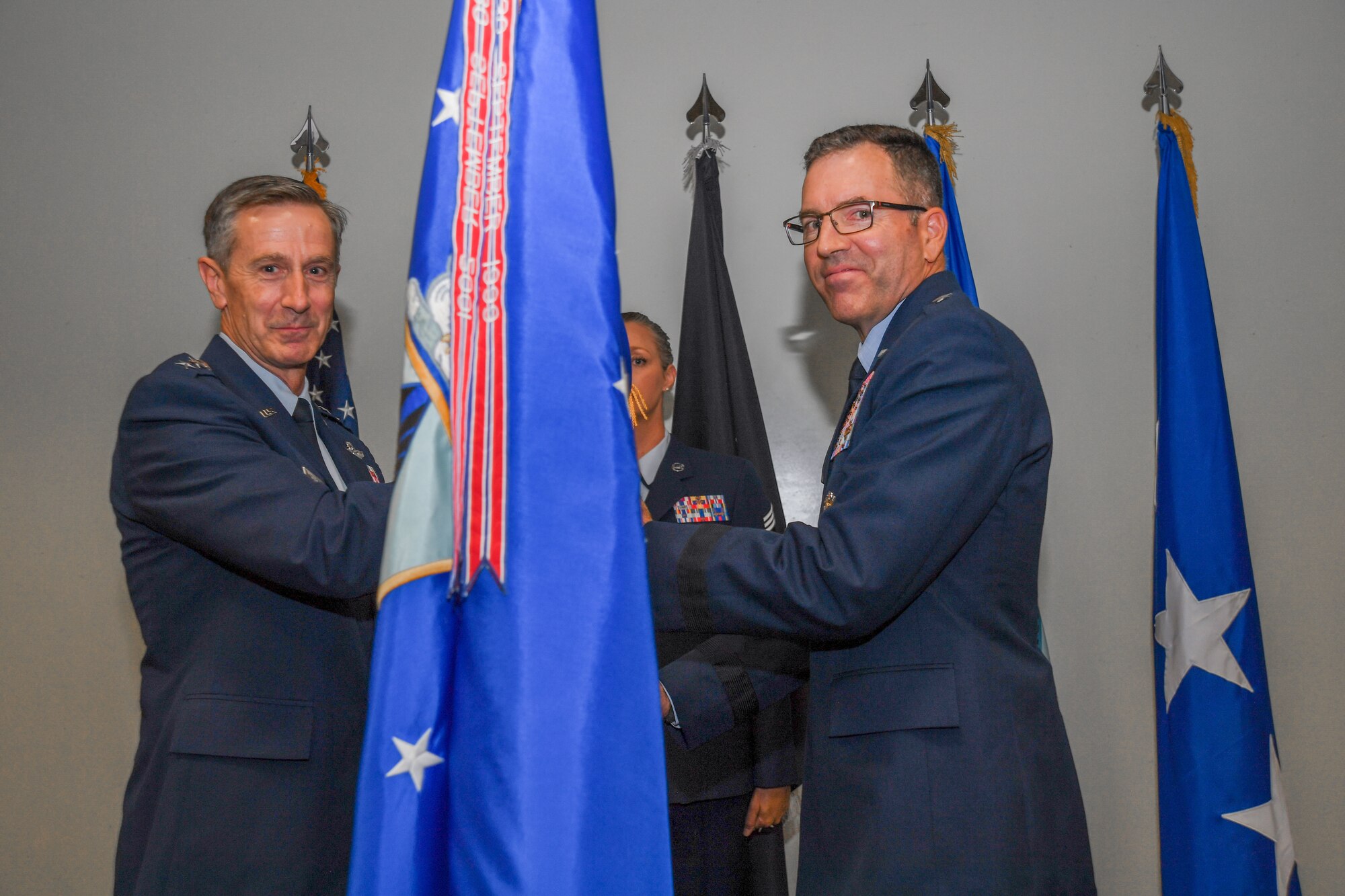 Lt. Gen. Kevin B. Schneider, Department of the Air Force director of staff, passes the Air Force Safety Center guidon to Brig. Gen. Sean M. Choquette, incoming AFSEC commander
