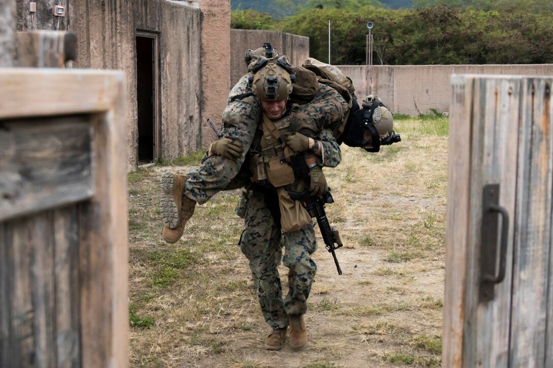 A U.S. Marine with Advanced Infantry Training Battalion, School of Infantry-West, Hawaii Detachment, carries a simulated casualty during urban operations training, Marine Corps Training Area Bellows, July 11, 2023. The training was conducted as part of the Advanced Infantry Marine Course. AIMC is designed to enhance and test Marines’ skills with a focus on reinforcing proper patrols and operational procedures. (U.S. Marine Corps photo by Cpl. Chandler Stacy)