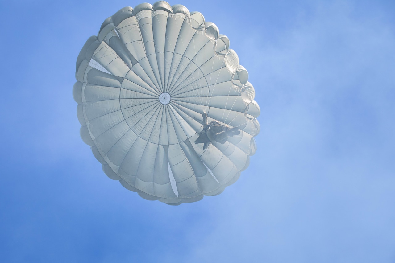 A paratrooper descends from the sky.