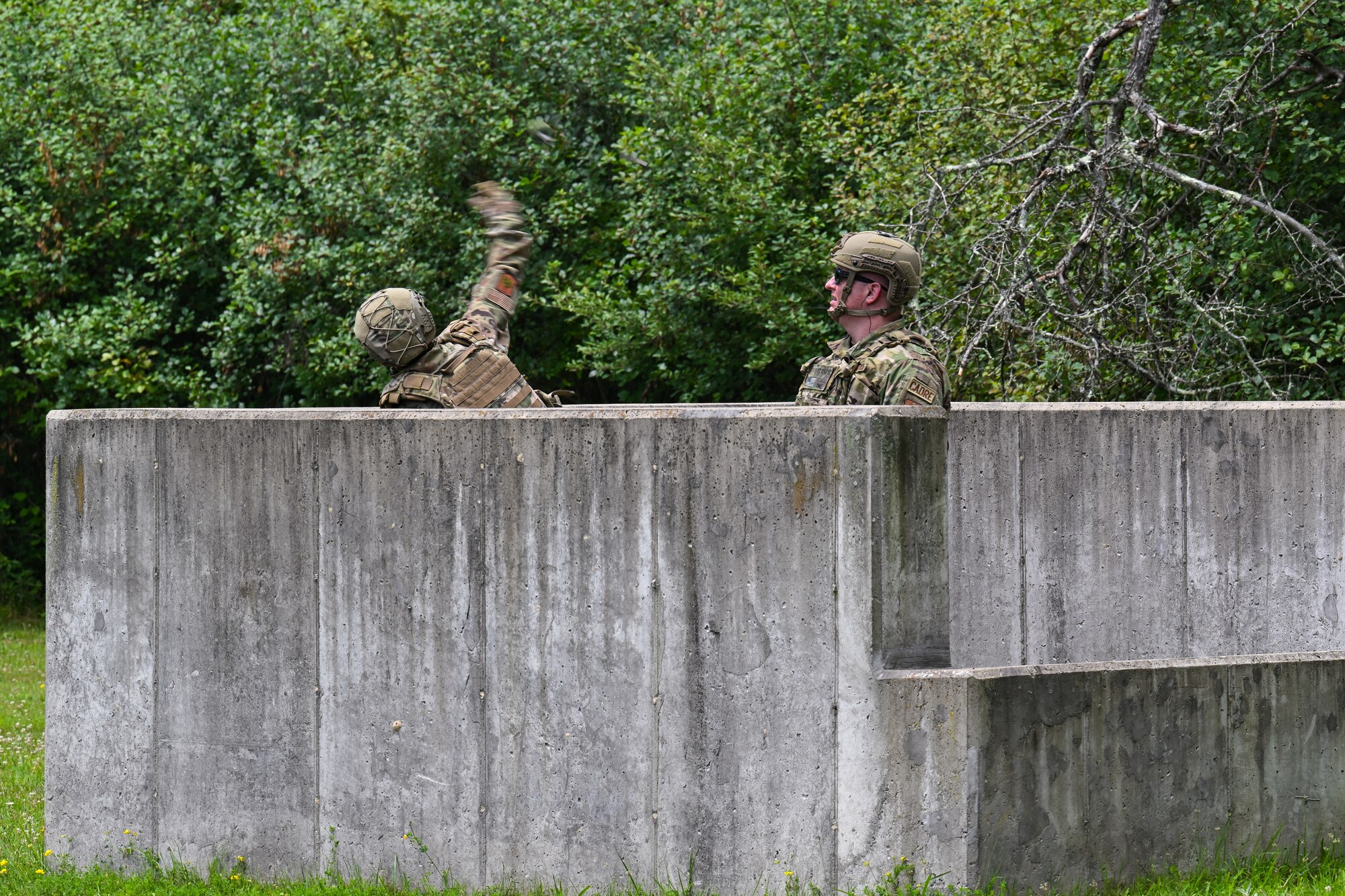 Tech. Sgt. Cara Shaw, an Integrated Defense Leadership Course cadre member assigned to the 307th Security Forces Squadron, Barksdale Air Force Base, Louisiana, and Senior Master Sgt. Daniel Chase, IDLC chief assigned to the 310th SFS, Schriever Space Force Base, Colorado, prepare to detonate a grenade on July 21, 2023, at Camp James A. Garfield Joint Military Training Center, Ohio.