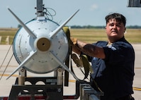 Senior Airman Antonio Mutt, 5th Aircraft Maintenance Squadron weapons loader, moves an inert precision guided munition at Minot Air Force Base, North Dakota, Aug. 3, 2023. Mutt and his team competed in the Global Strike Challenge to test performance and readiness. (U.S. Air Force photo by Airman 1st Class Kyle Wilson)