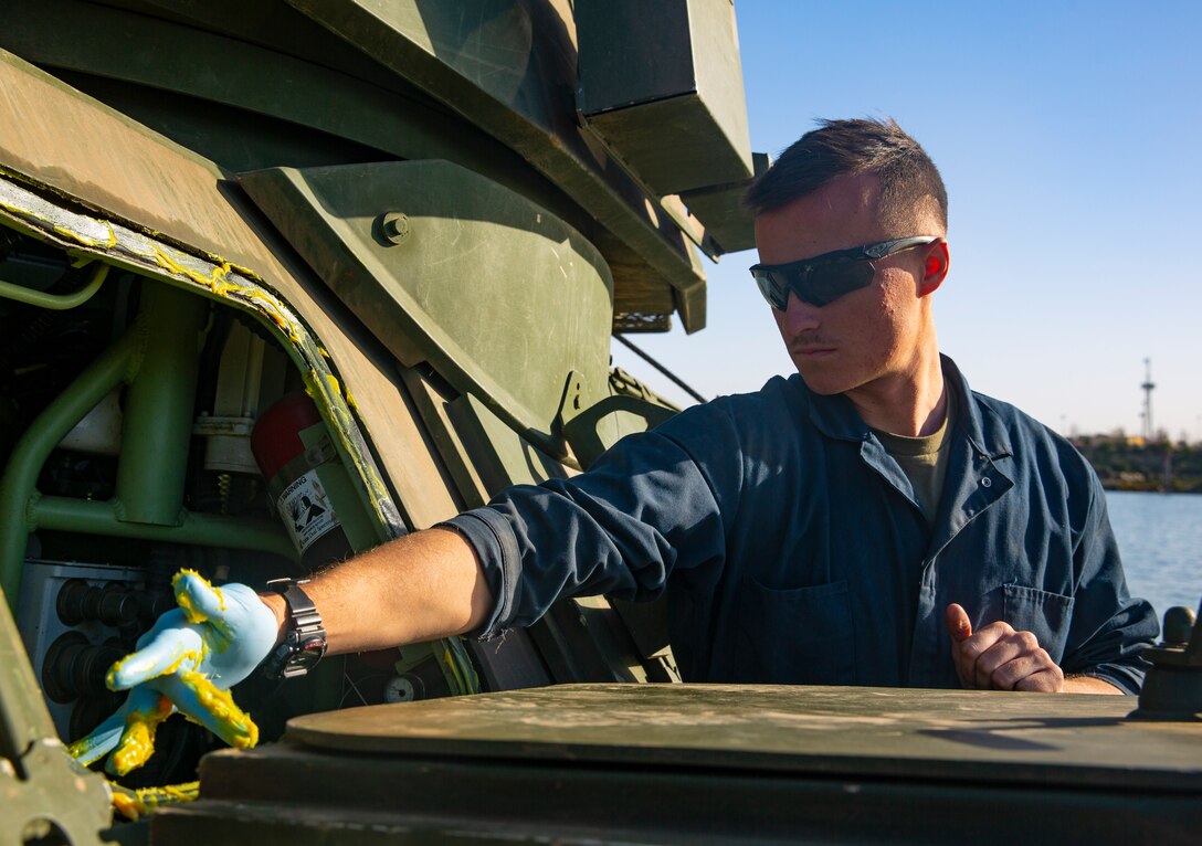 U.S. Marine Pfc. Joshua Waldhauser, a student with Light Armored Reconnaissance Training Company, Advanced Infantry Training Battalion, School of Infantry - West, applies grease to a LAV-25 Light Armored Vehicle prior to LAR Marine Course 2-20’s LAV swim operations at the Del Mar boat basin on Marine Corps Base Camp Pendleton, California, Feb. 11, 2020. The mission of LARTC is to train entry-level light armored reconnaissance crewmen in the tactical employment of the LAV. Waldhauser is a native of Baltimore. (U.S. Marine Corps photo by Lance Cpl. Melissa I. Ugalde)