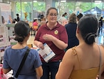 Woman getting her face painted by another woman.