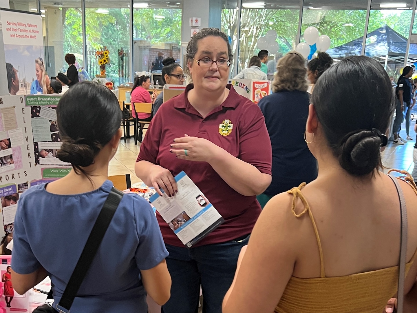 Nurse talking to two women at the Health Fair.