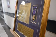 Photo of  plaque displaying the names of past and present Tobyhanna Army Depot employees who have earned a Purple Heart.