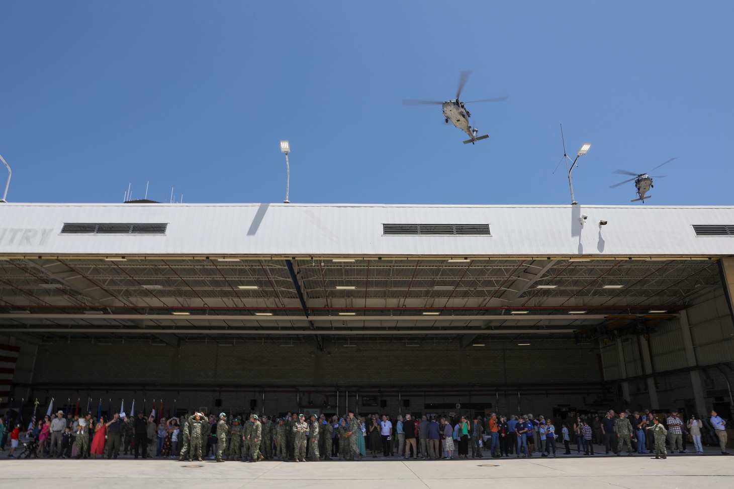MH-60S Seahawks assigned to the "Firehawks" of Helicopter Sea Combat Squadron (HSC) 85 fly over the squadron's hangar during the squadron's deactivation ceremony.