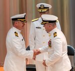 Capt. Nate Schneider, at right, presents the SUPSHIP Gulf Coast command pin to Capt. Randy Slaff, signifying the transfer of authority and responsibility for the command. Looking on is Rear Admiral Tom Anderson, Program Executive Officer for Ships.