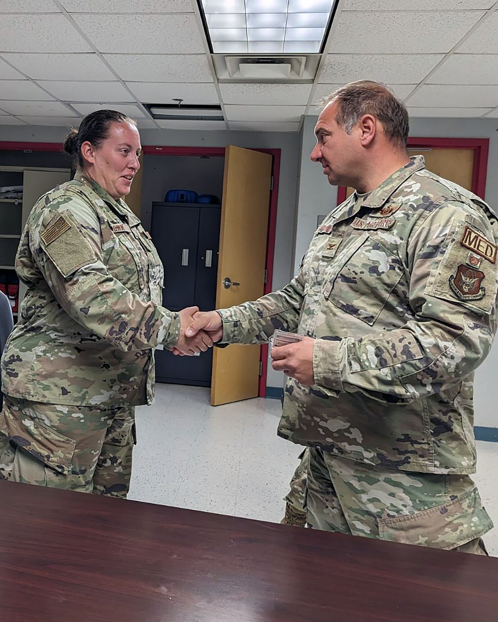 Senior Master Sgt. Jasmine Brown, 55th Combat Communications Squadron, is coined by Col. Joseph Catalino, commander of the 439th Aeromedical Evacuation Squadron at Westover Air Reserve Base, Massachusetts on July 22, 2023. (Courtesy photo)