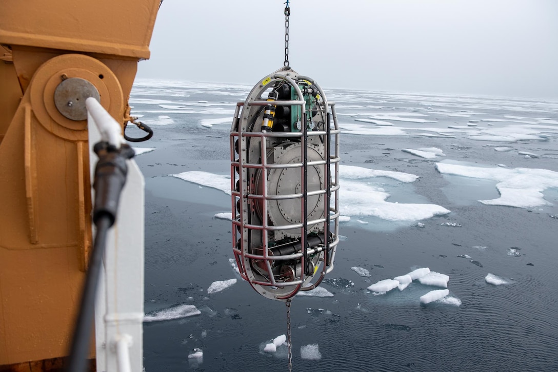 Researchers aboard Coast Guard Cutter Healy (WAGB 20) prepare a winch for the Very Low Frequency Sound Source deployment in the Beaufort Sea, Aug. 2, 2023. Healy is designed to conduct a wide range of research activities, providing more than 4,200 square feet of scientific laboratory space, numerous electronic sensor systems, oceanographic winches, and accommodations for up to 50 scientists. (Coast Guard photo by Petty Officer 3rd Class Briana Carter)