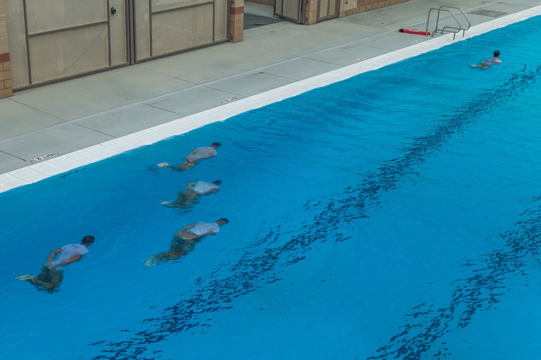 U.S. Marine Corps Basic Reconnaissance Primer Course 9-18 students with Recon Training Company, Advanced Infantry Training Battalion, School of Infantry-West, conduct the restricted lap swim portion of the Reconnaissance Aquatics Competency Test (RACT) at the Area 53 Pool at Marine Corps Base Camp Pendleton, California, Sept. 24, 2018. The RACT consisted of each student executing a series of aquatic exercises while having their feet tied together and their hands placed behind their back. The students conducted the RACT in preparation for follow-on training in the U.S. Marine Corps Combatant Diver Course where the same test is a requirement for course completion. (U.S. Marine Corps photo by Lance Cpl. Kerstin Roberts)