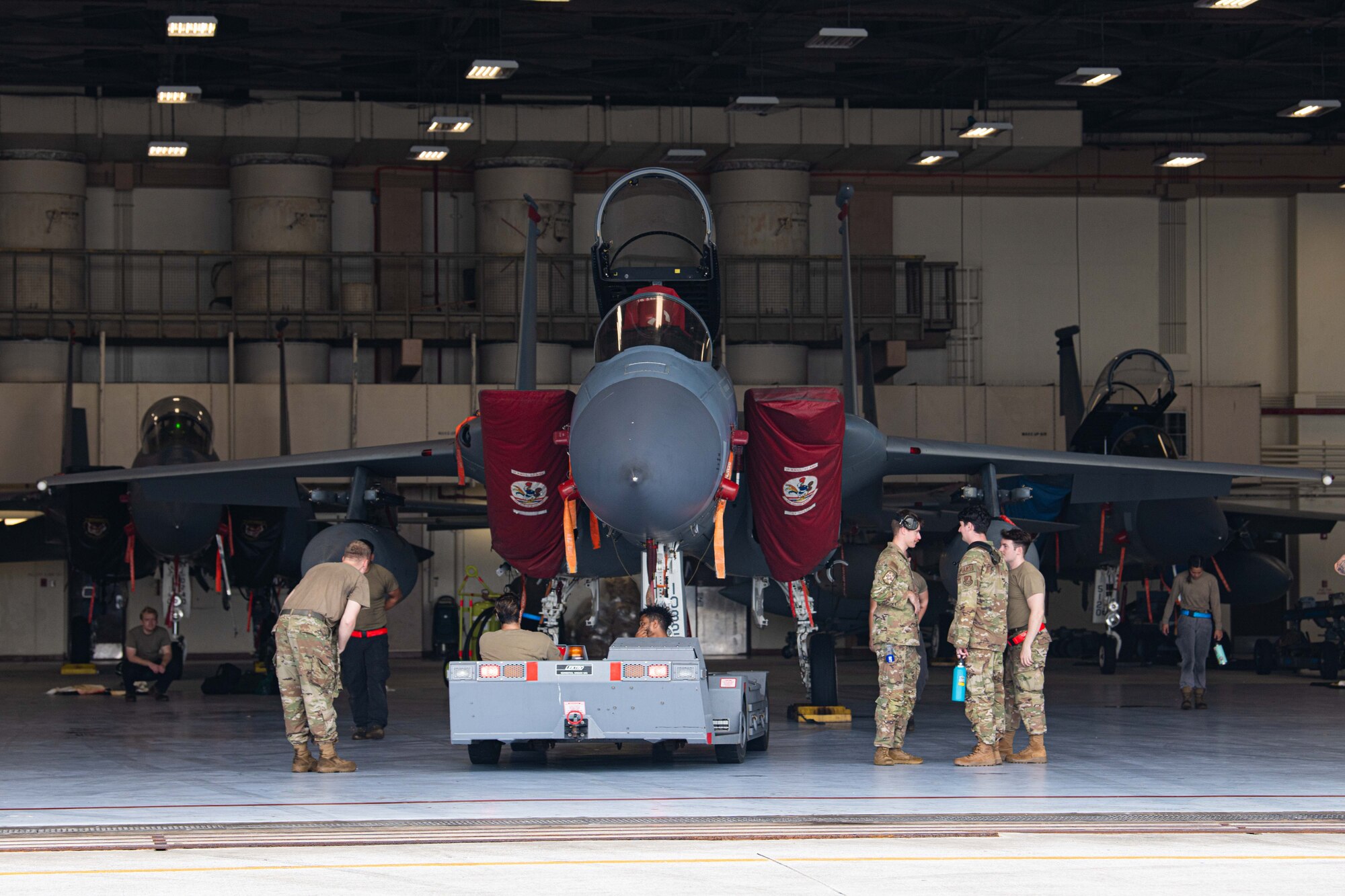 Airmen from the 18th Aircraft Maintenance Squadron tow an F-15C Eagle.