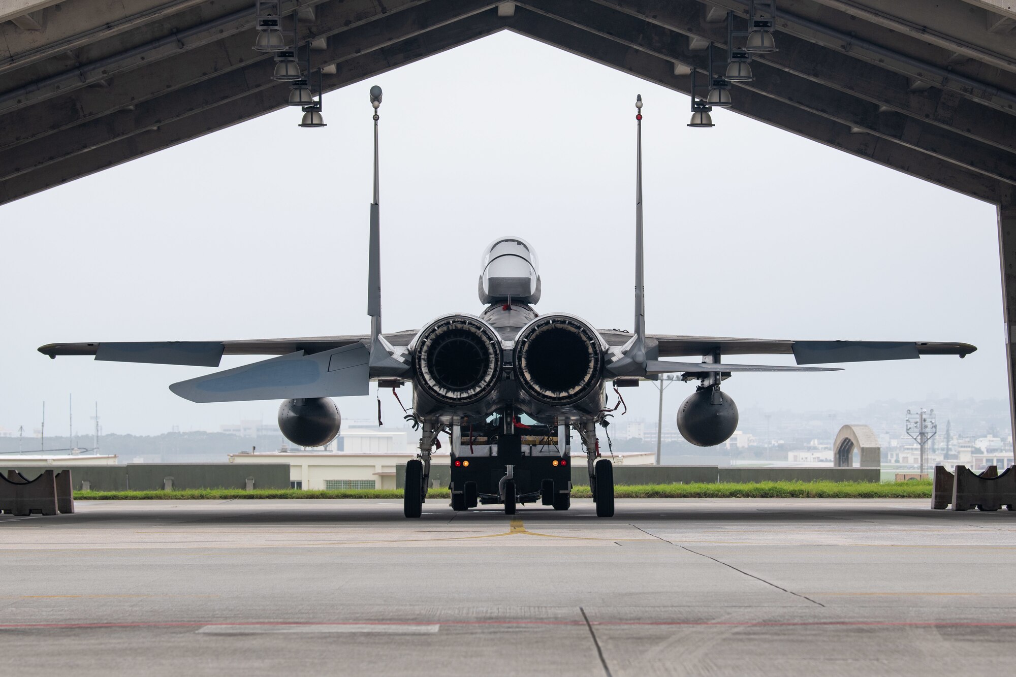 A towing crew returns an F-15C Eagle to its parking spot.