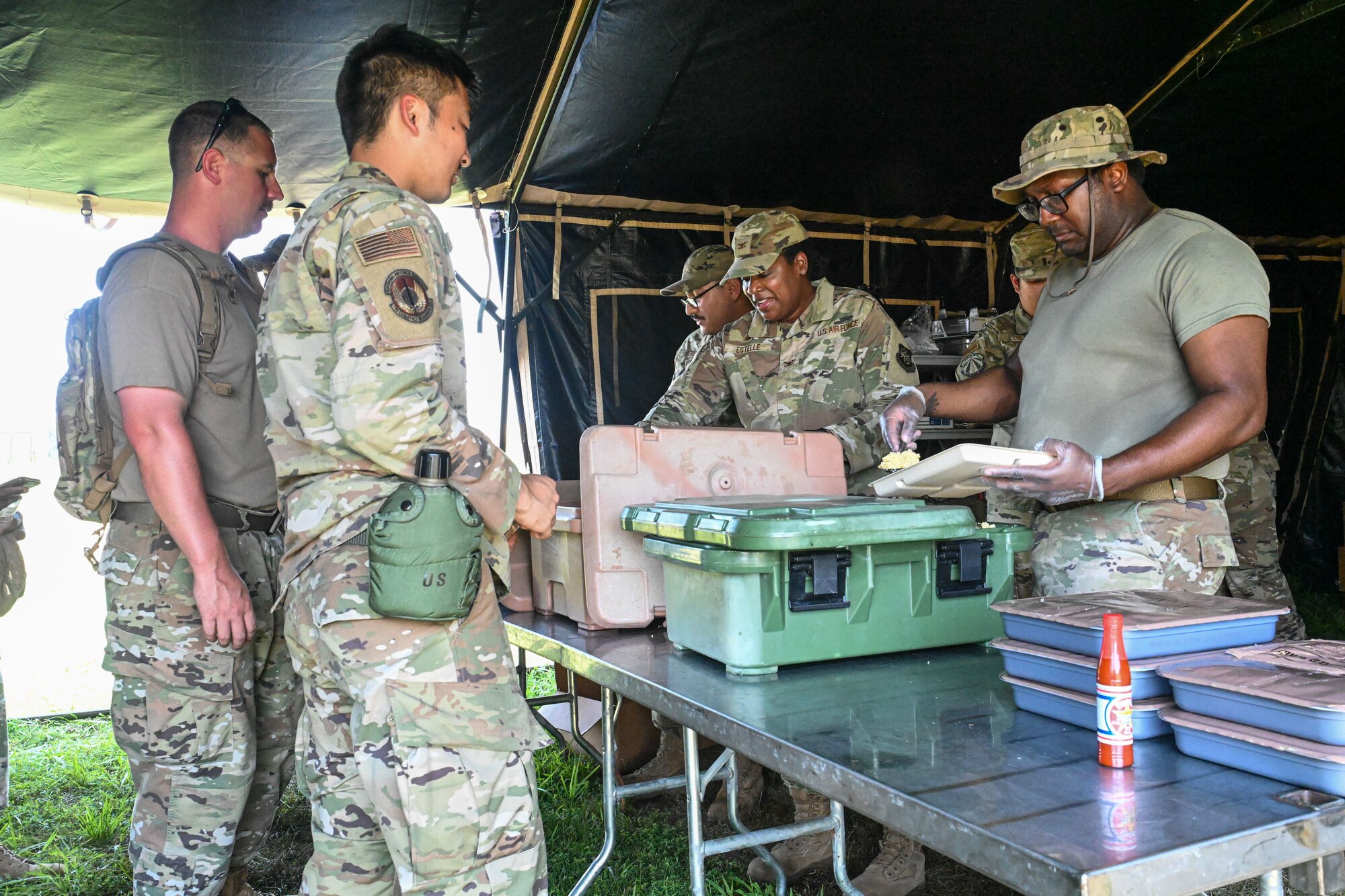 Airmen serve food to other Airmen.