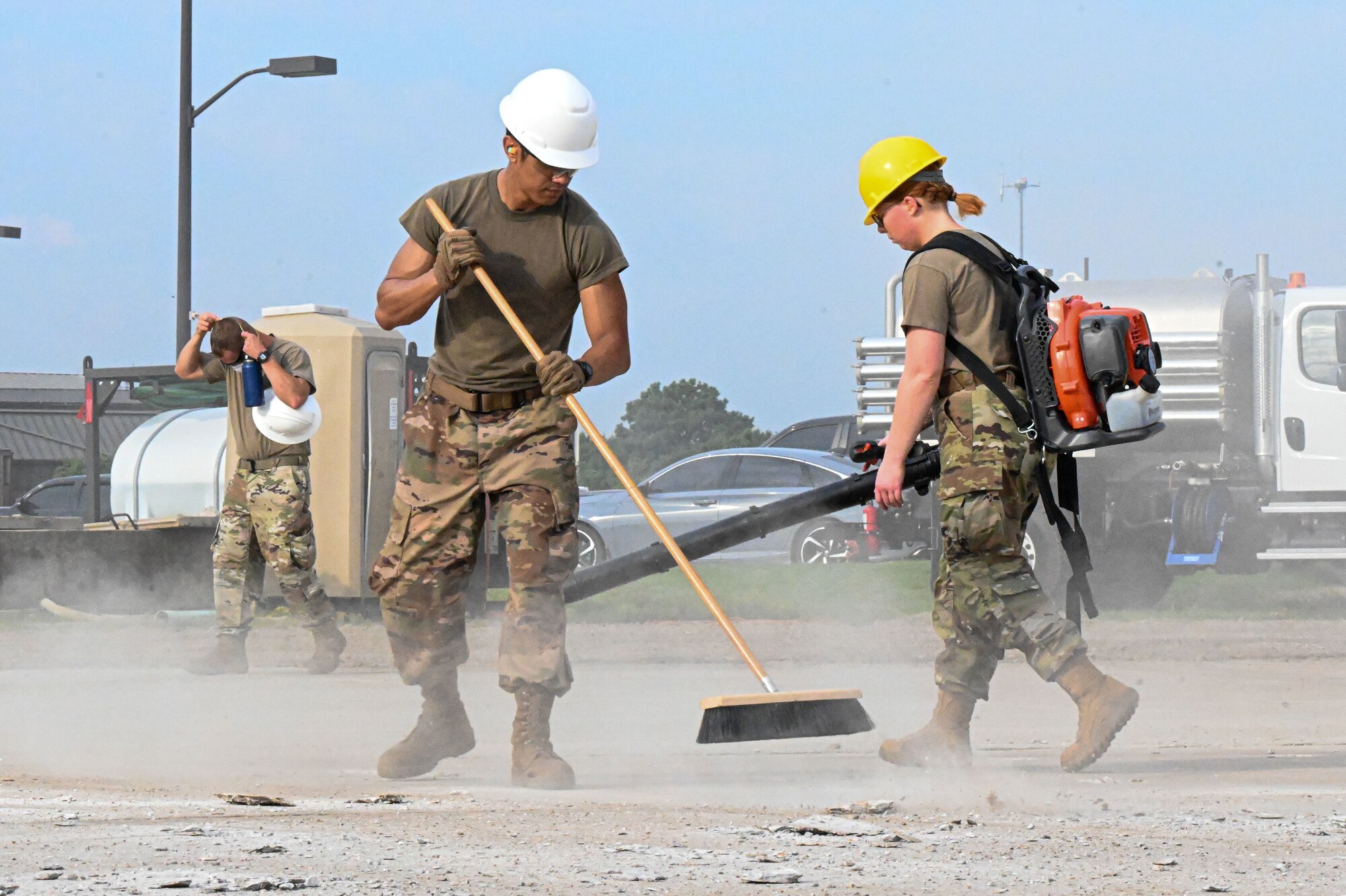 Airmen clear debris on a runway.