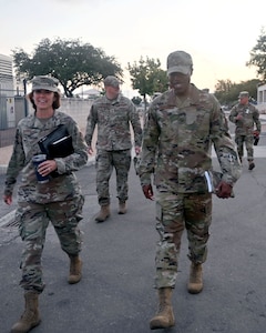 Brig. Gen. Regina Sabric (left), 10th Air Force commander, and Chief Master Sgt. Christopher Bluto, 10th Air Force command chief, proceed to a briefing on the status of Air Force Reserve Command's cyberspace operations at Joint Base San Antonio-Lackland, Texas on August 8, 2023. She is accompanied by Col. Silas Darden (right), 960th Cyberspace Wing commander, and Chief Master Sgt. Christopher Howard (center), 960th Cyberspace Wing command chief. (Air Force photo by 2nd Lt. Alex Dieguez)
