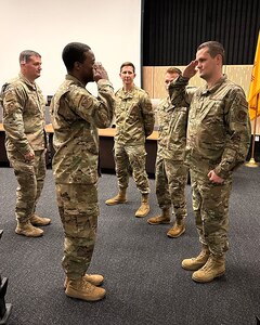 Master Sgt. Colby Teafatiller, 53rd Network Operations Squadron, salutes Col. Silas Darden, 960th Cyberspace Wing commander, after being coined at the Central New Mexico Community College in Albuquerque, New Mexico on July 20, 2023. (Courtesy photo)
