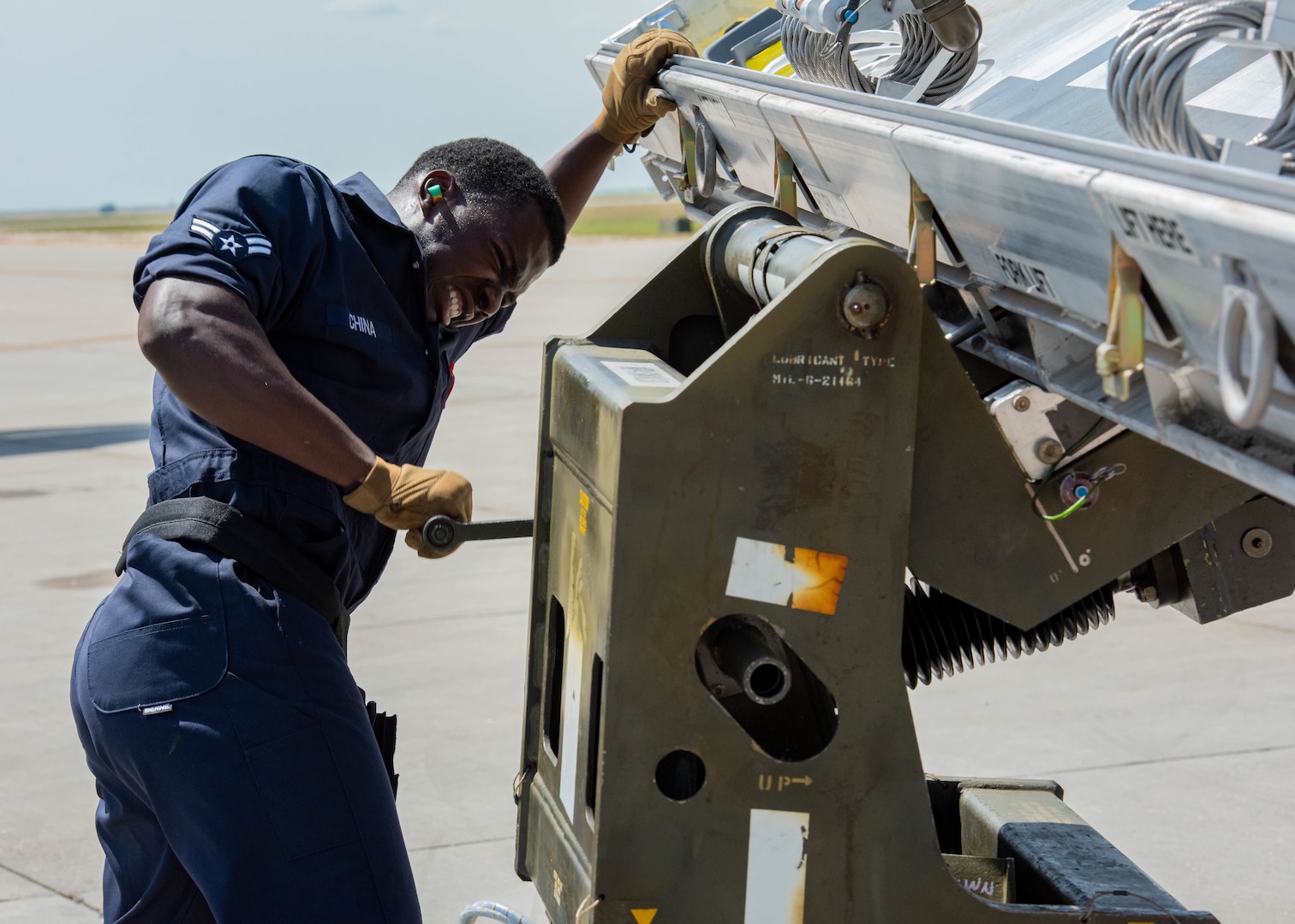 Airman 1st Class Noah China, 5th Aircraft Maintenance Squadron weapons loader, cranks a lever at Minot Air Force Base, North Dakota, Aug. 3, 2023. China helped his team transport weapons systems and load them onto a B-52H Stratofortress during the Global Strike Challenge. (U.S. Air Force photo by Airman 1st Class Kyle Wilson)