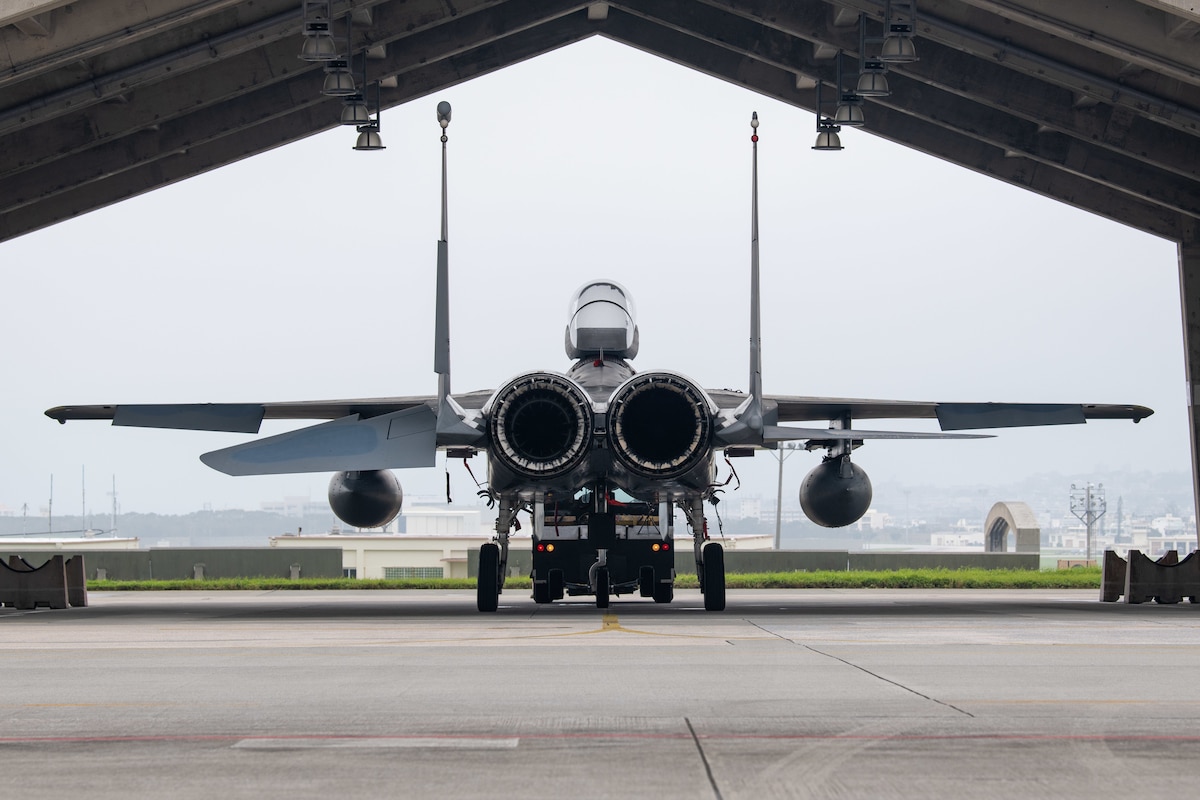 A towing crew returns an F-15C Eagle to its parking spot.
