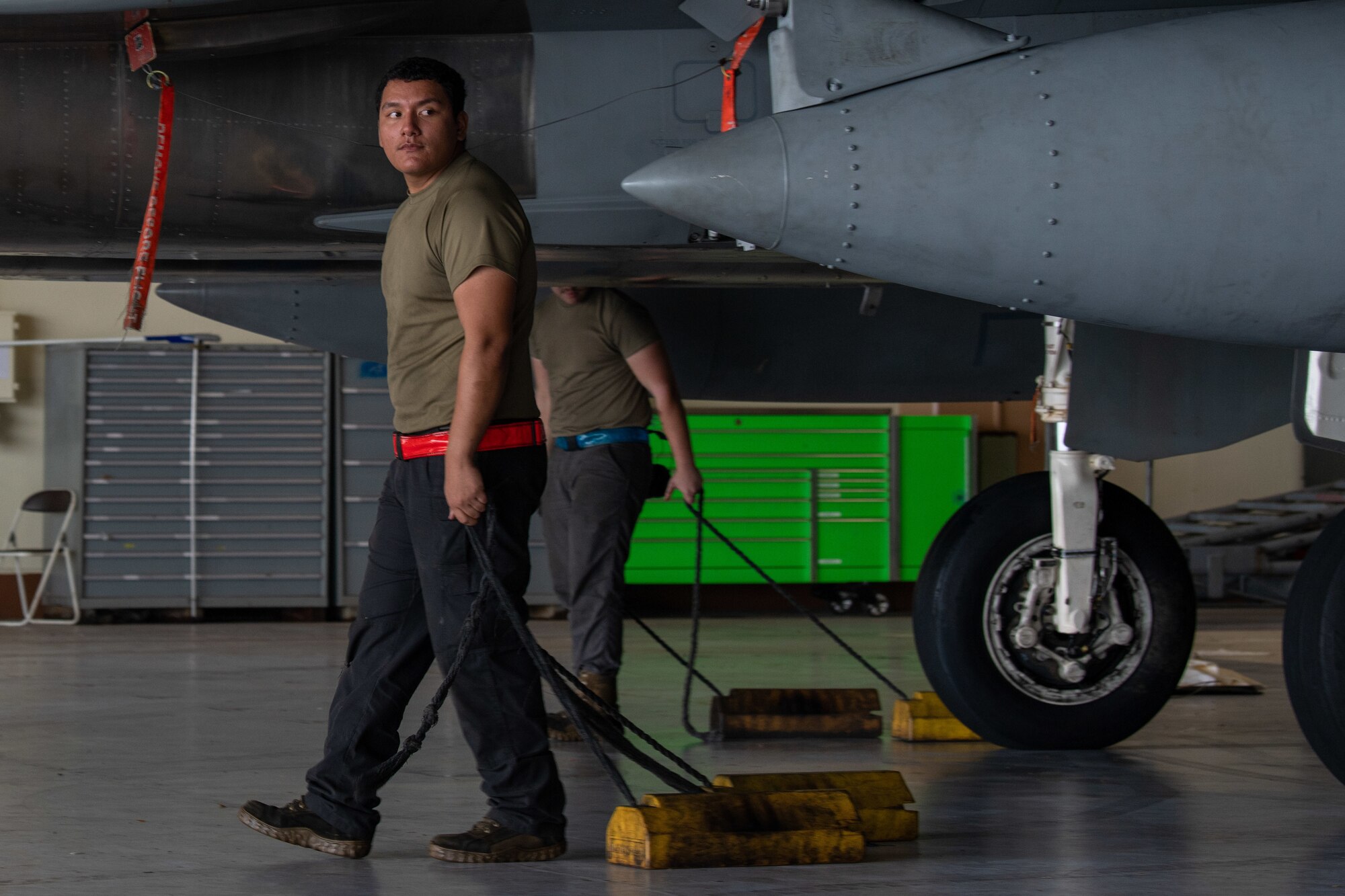 Assistant dedicated crew chief walks alongside an F-15C Eagle.
