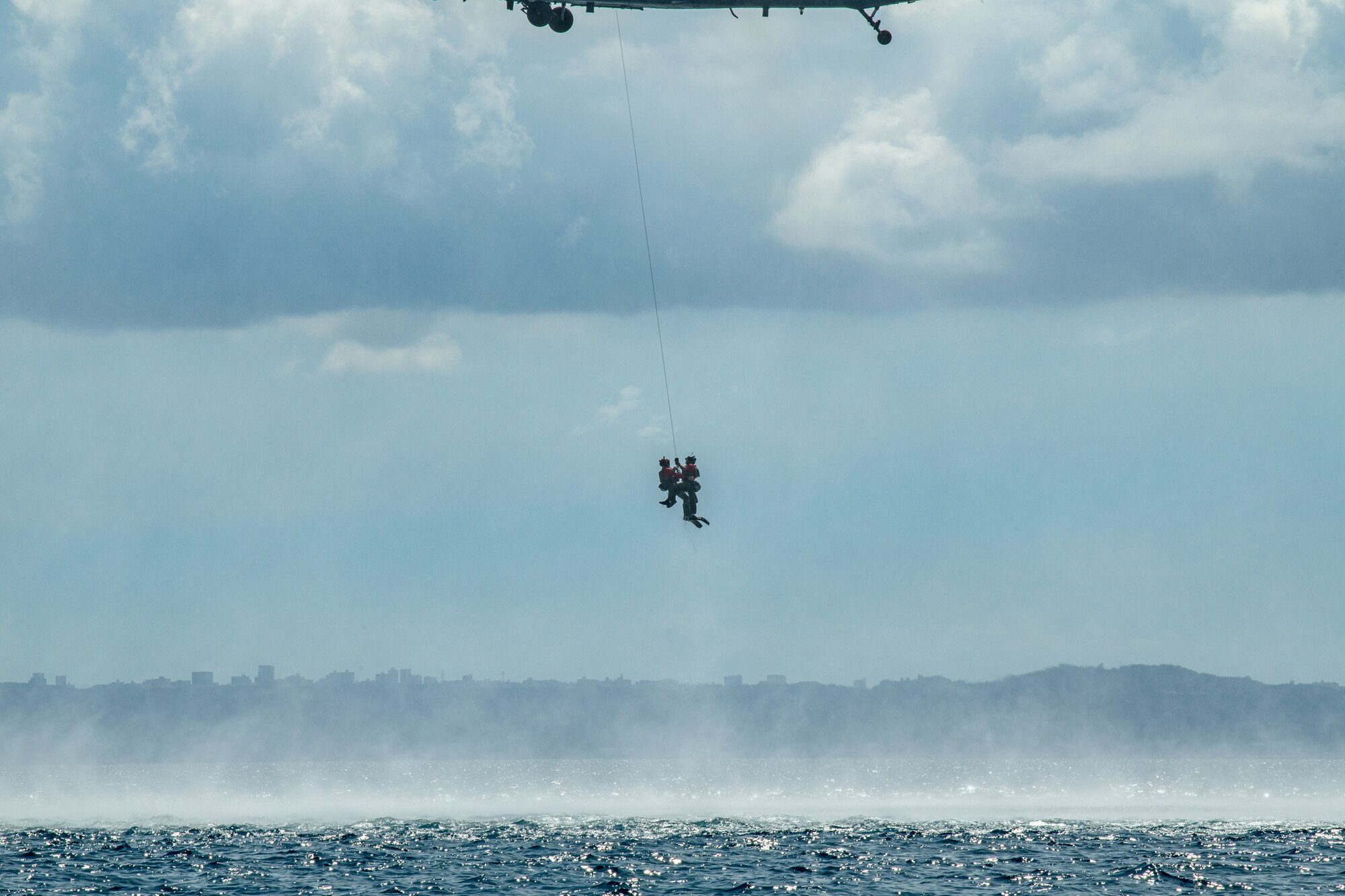 Two people airlifted into a helicopter.
