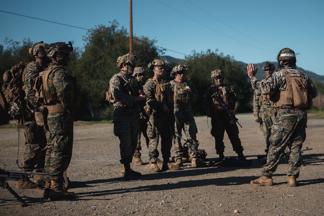 U.S. Marine Sgt. Brian Lopez, a combat instructor for the Advanced Machine-Gun Course, School of Infantry - West, Advanced Infantry Training Battalion, debriefs students during a live-fire exercise at Range 218 on Marine Corps Base Camp Pendleton, California, Feb. 16, 2022. AMGC is a six-week course where machine gunners advance their warfighting and weaponry skills, as well as their land navigation and small unit leadership. (U.S. Marine Corps photo by Lance Cpl. Shaina Jupiter)