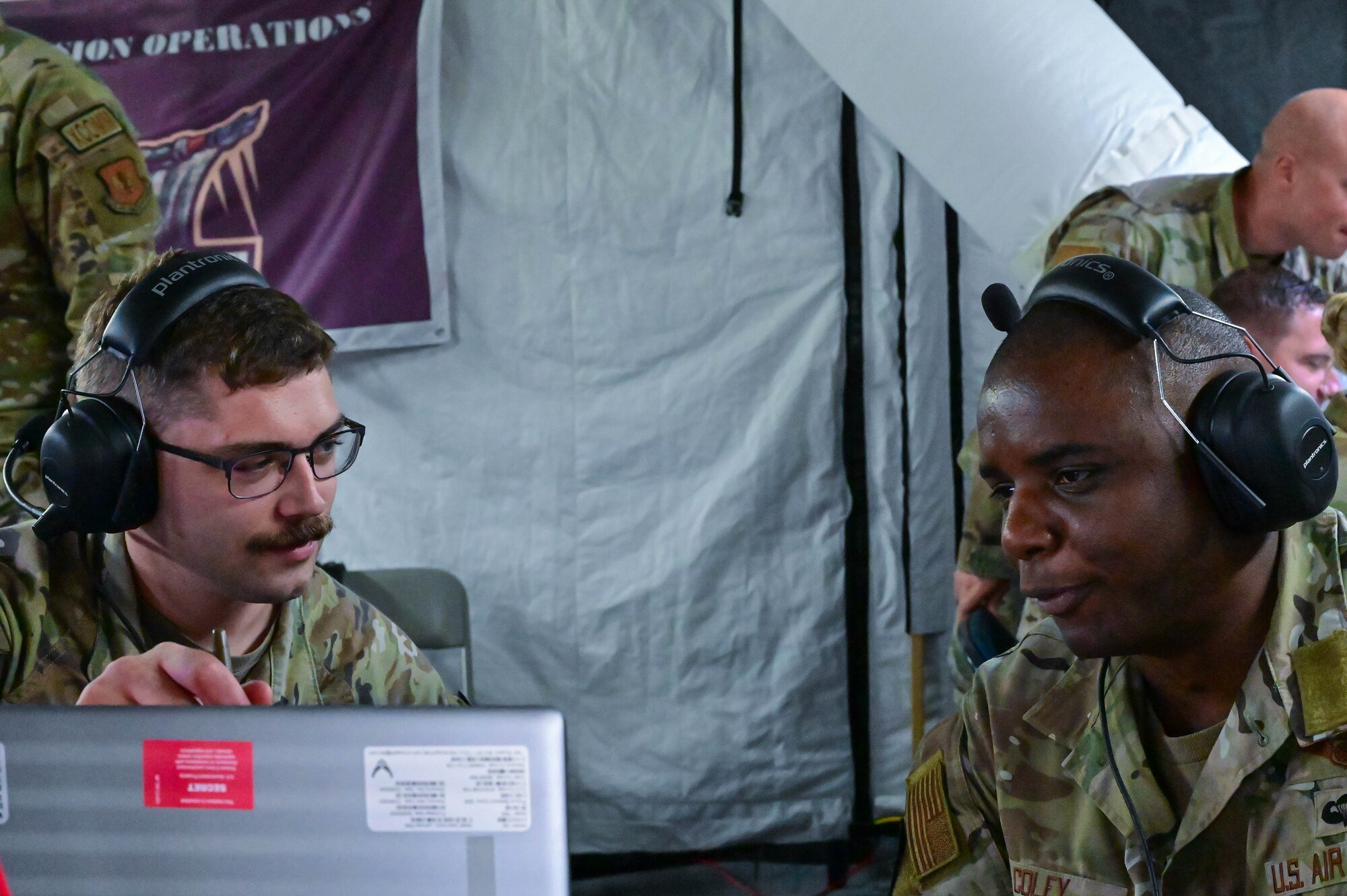 men in uniform lookin at a computer together