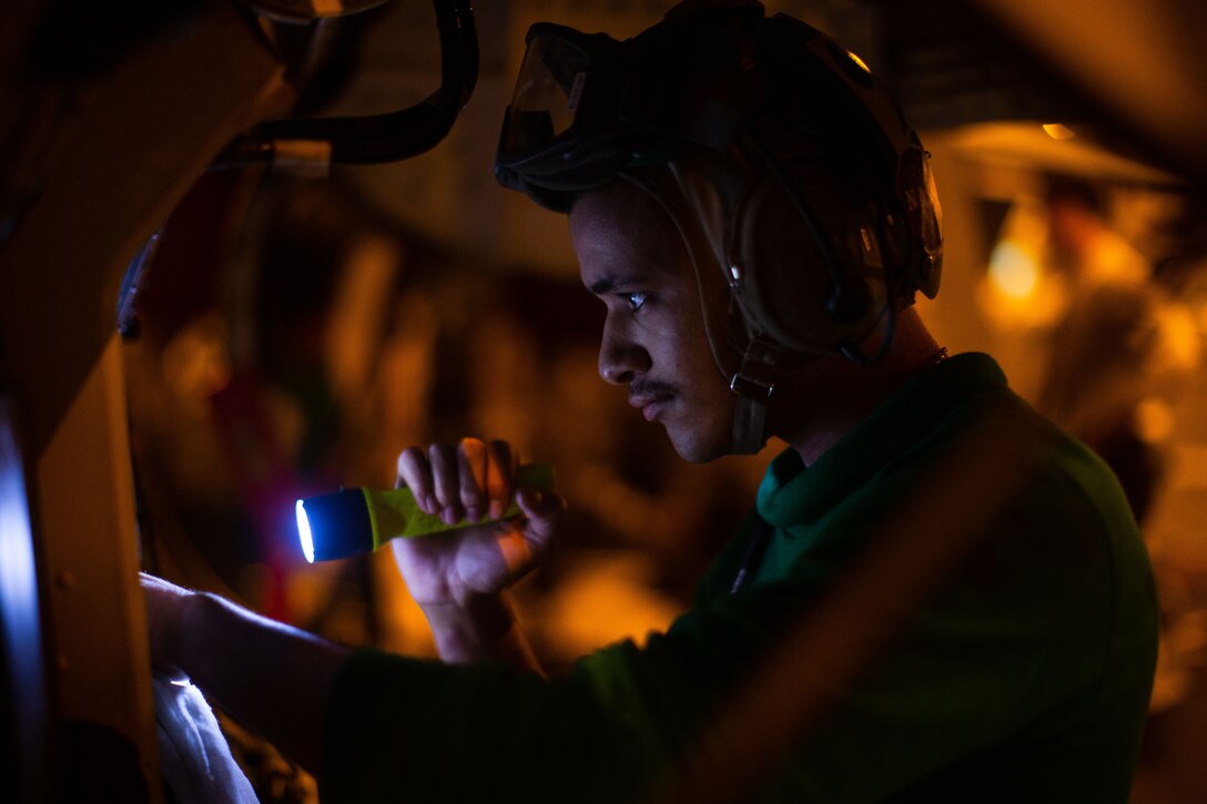 A sailor conducts maintenance on an F/A-18F Super Hornet.