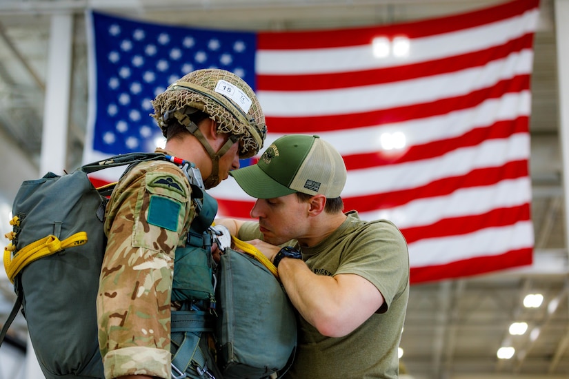 A man inspects a paratrooper's equipment.