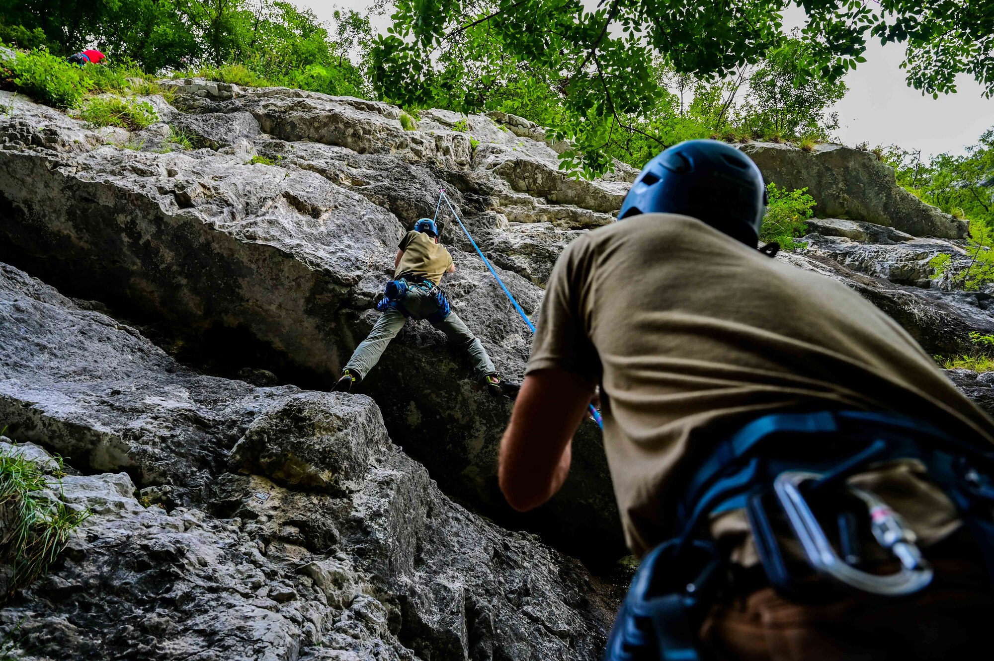 U.S. Air Force Senior Airman Sean Carey 31st Maintenance group aerospace ground equipment journeyman, communicates with his climbing partner as he ascends a rock-climbing wall.