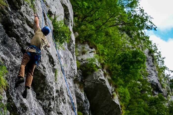 U.S. Air Force Senior Airman Sean Carey, 31st Maintenance group aerospace ground equipment journeyman, ascends a medium difficulty wall for the first time at a rock-climbing wall.