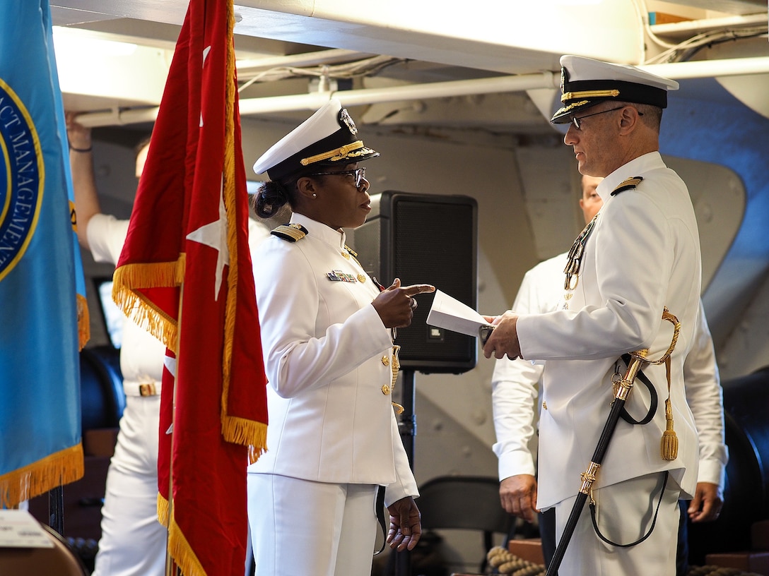 Two Navy officers in white uniforms talking